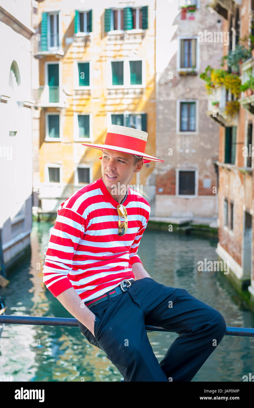 VENICE, ITALY - CIRCA APRIL, 2013: Venetian gondolier in traditional red and white striped shirt Stock Photo