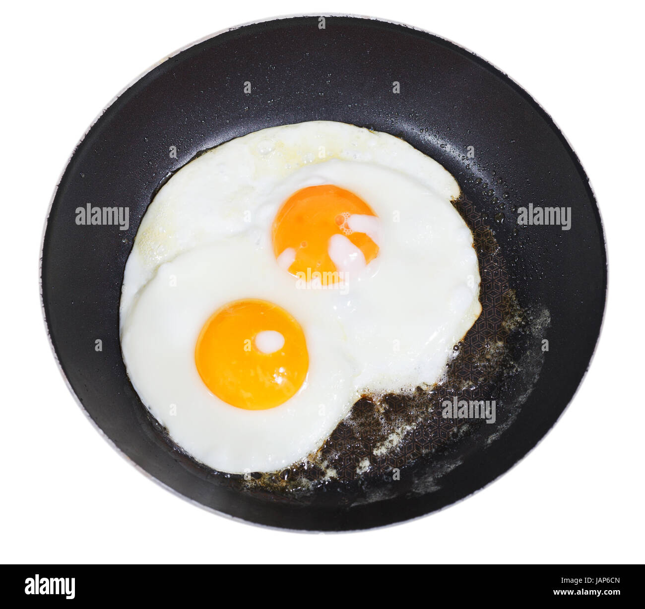 top view of two fried eggs in frying pan isolated on white background ...