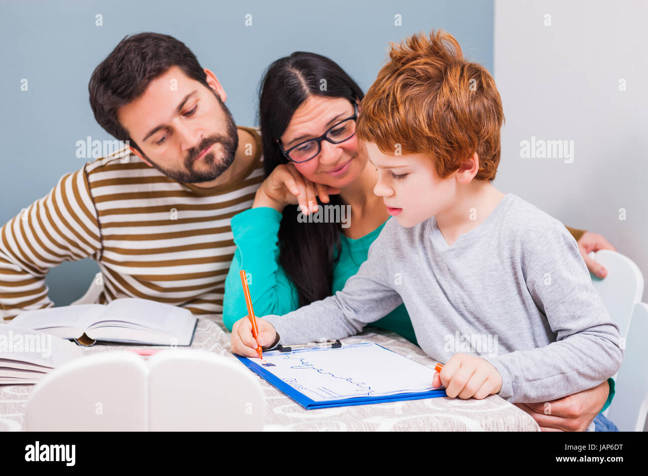 Parents are teaching their son at home Stock Photo - Alamy