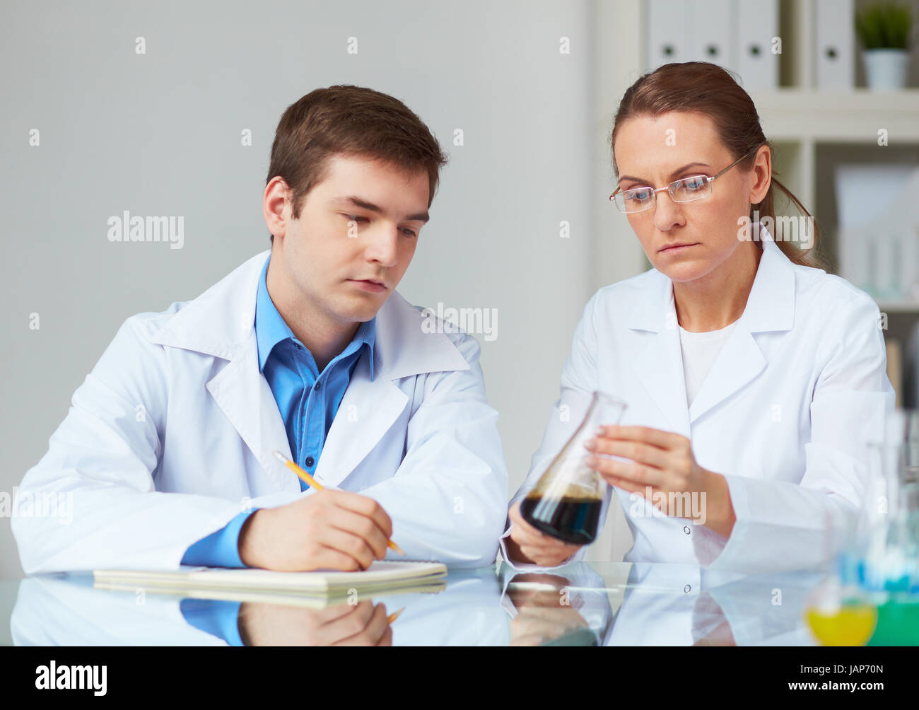 Two scientists looking glass hi-res stock photography and images - Alamy