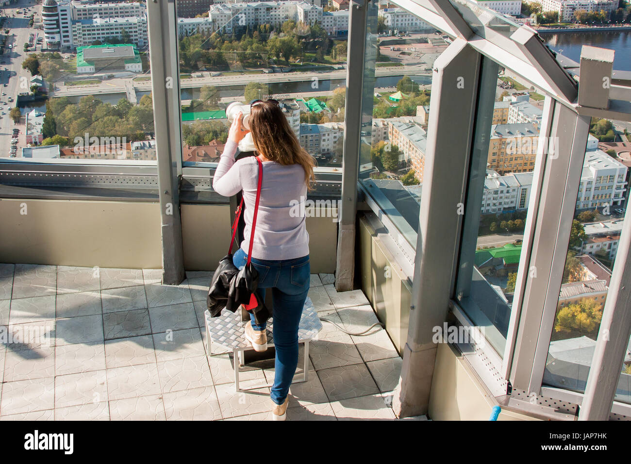 Yekaterinburg, Russia - September 24.2016: Woman looking in the viewing glass on the beautiful view from the observation deck 52 floors of the skyscra Stock Photo