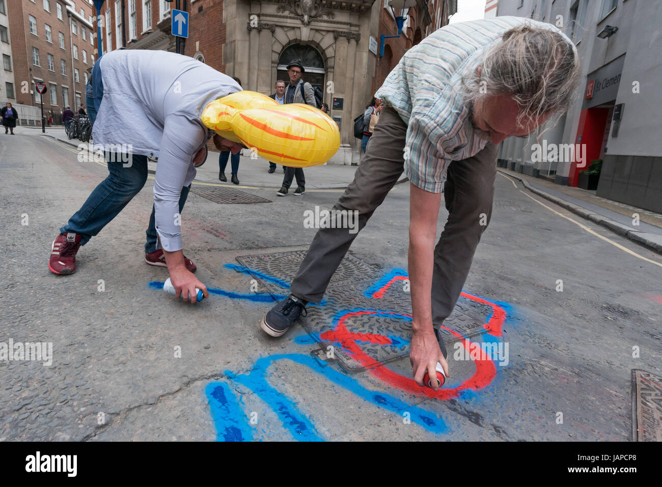 London, UK. 7th June 2017. Roger Hallam (right) and another protester end the chalking of the slogan 'LSE: Why Do Those With So Much Refuse To Give Dignity & Respect to the Cleaners - Equality Now!!!' at tjeLife Not Money at the LSE street theatre protest supporting London School of Economics cleaners who have taken a series of weekly strikes for equality. Credit: ZUMA Press, Inc./Alamy Live News Stock Photo