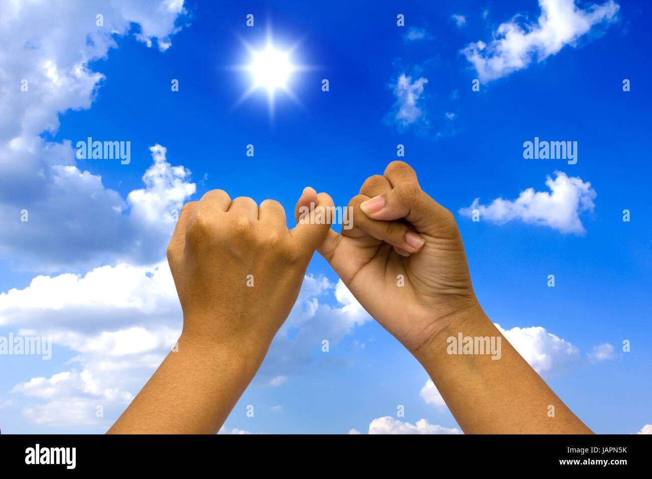 Two coupled hands on blue sky Stock Photo - Alamy
