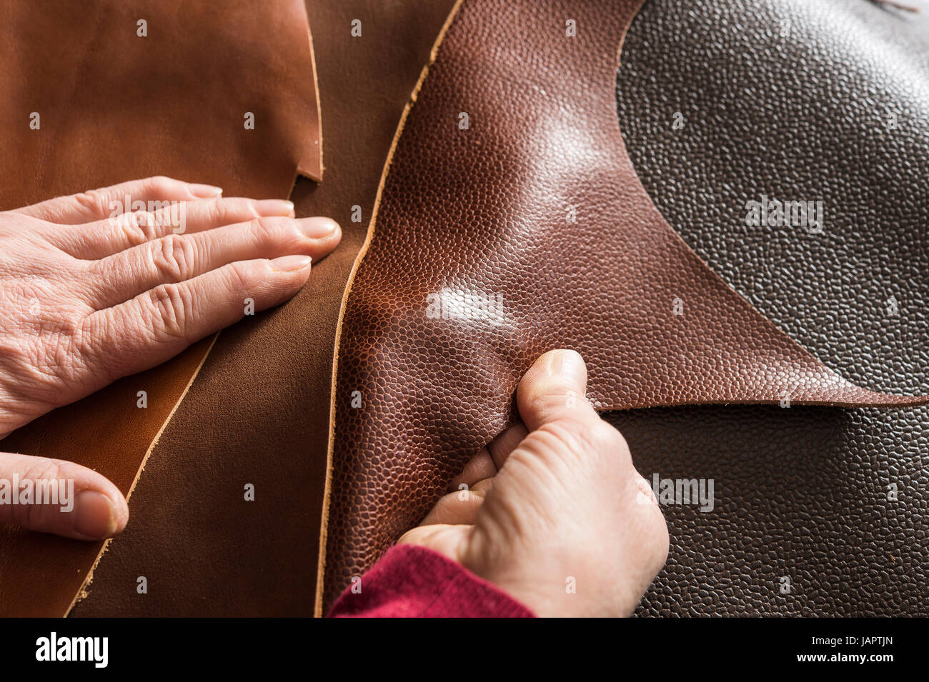Shoemaker, hands checking brown leathers, Kainisch, Styria, Austria Stock Photo