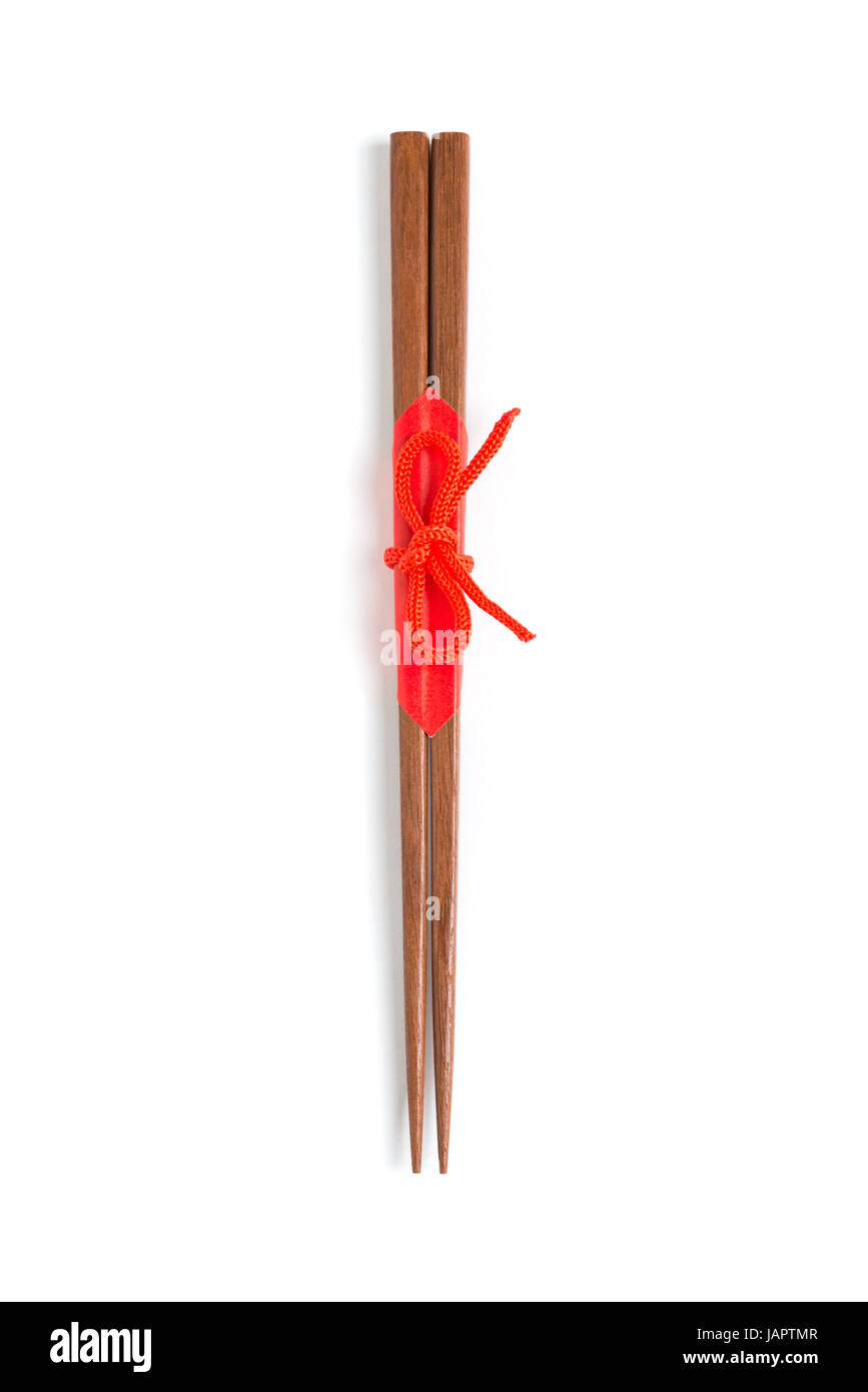Japanese wooden chopsticks wrapped in red paper and red rope on white background. Stock Photo