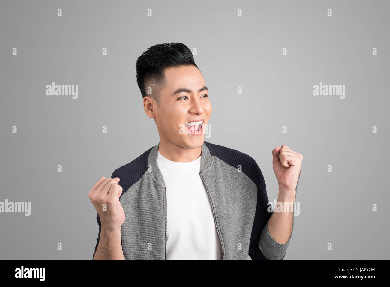 A portrait of happy excited young asian man with success positive ...