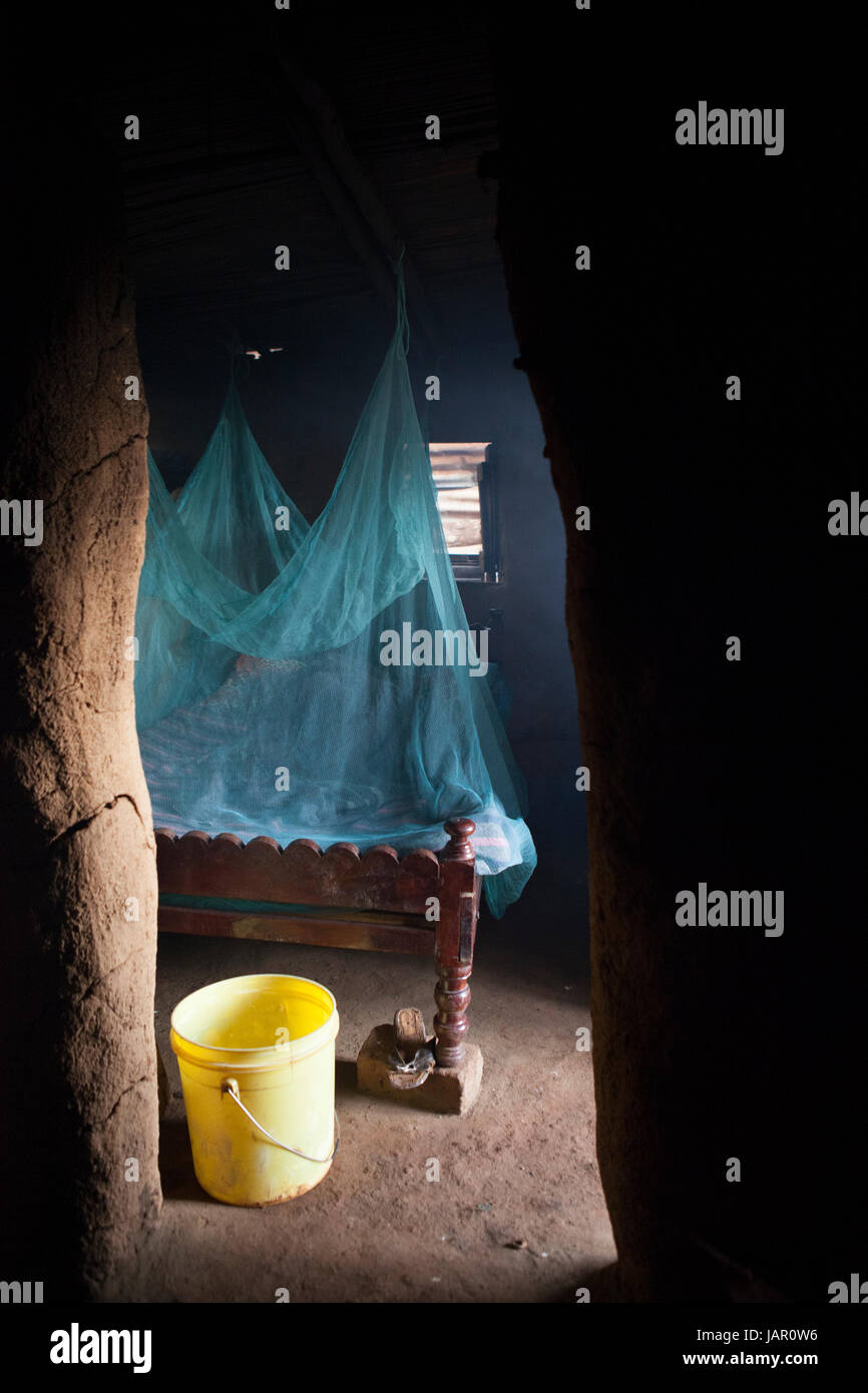 A mosquito net handing over a bed in a Kenyan hut, Africa Stock Photo