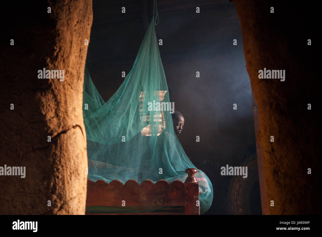 A mosquito net handing over a bed in a Kenyan hut, Africa. Stock Photo