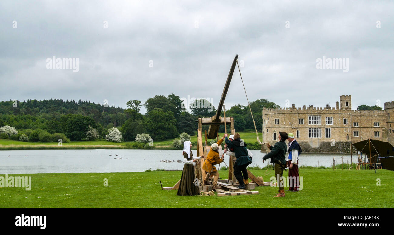 Loading a medieval trebouchet for shooting with medieval castle in the background Stock Photo