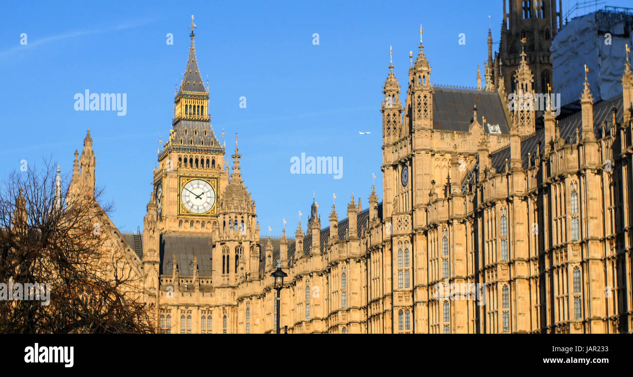 View of the House of Parliament and the Big Ben in London before sunset with an airplane Stock Photo