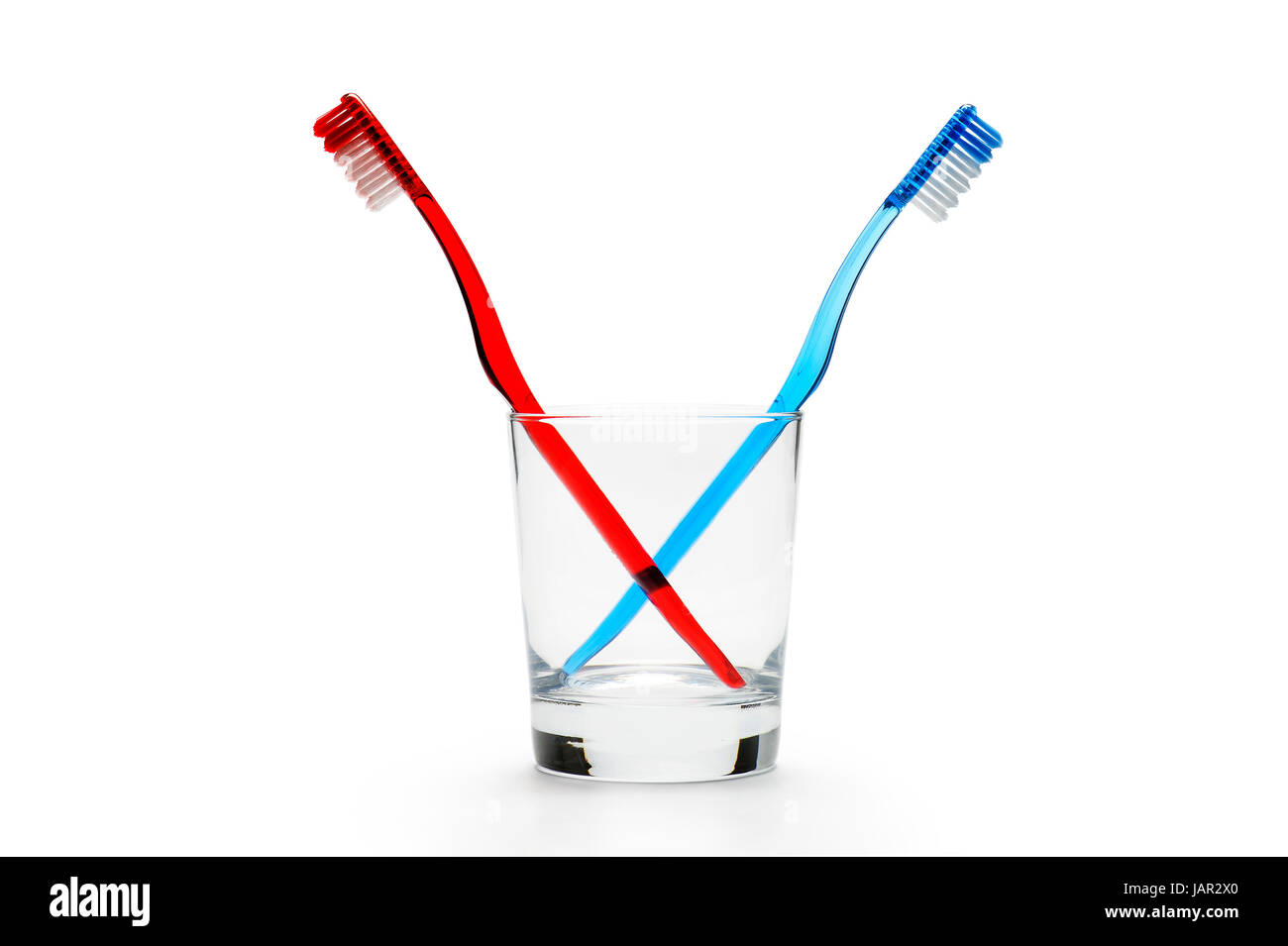 pair of toothbrushes in a glass, on white background, horizontal image ...