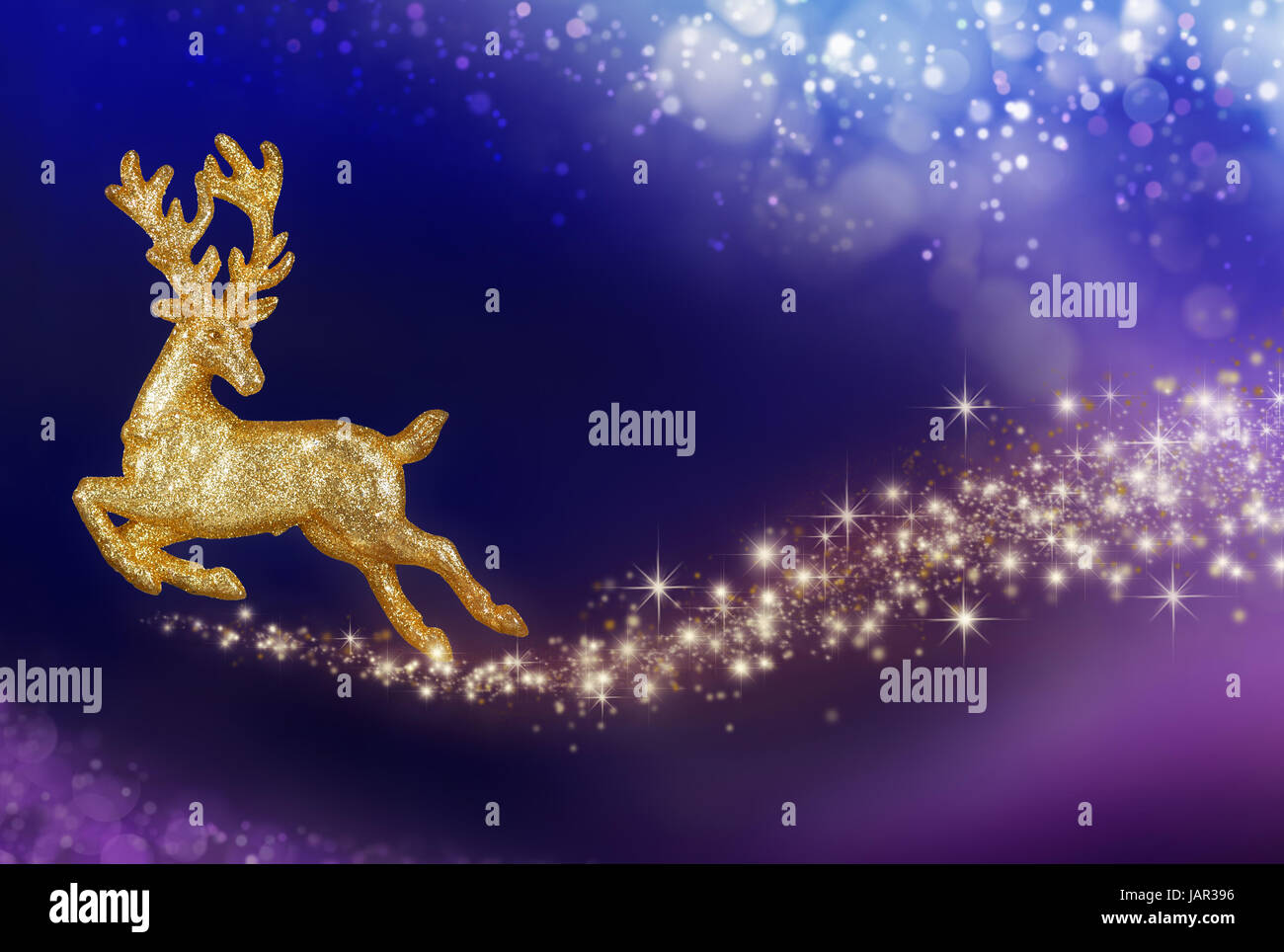 Goldenes Rentier fliegt in einem abstrakten Nachthimmel, mit glitzerndem Schweif Stock Photo