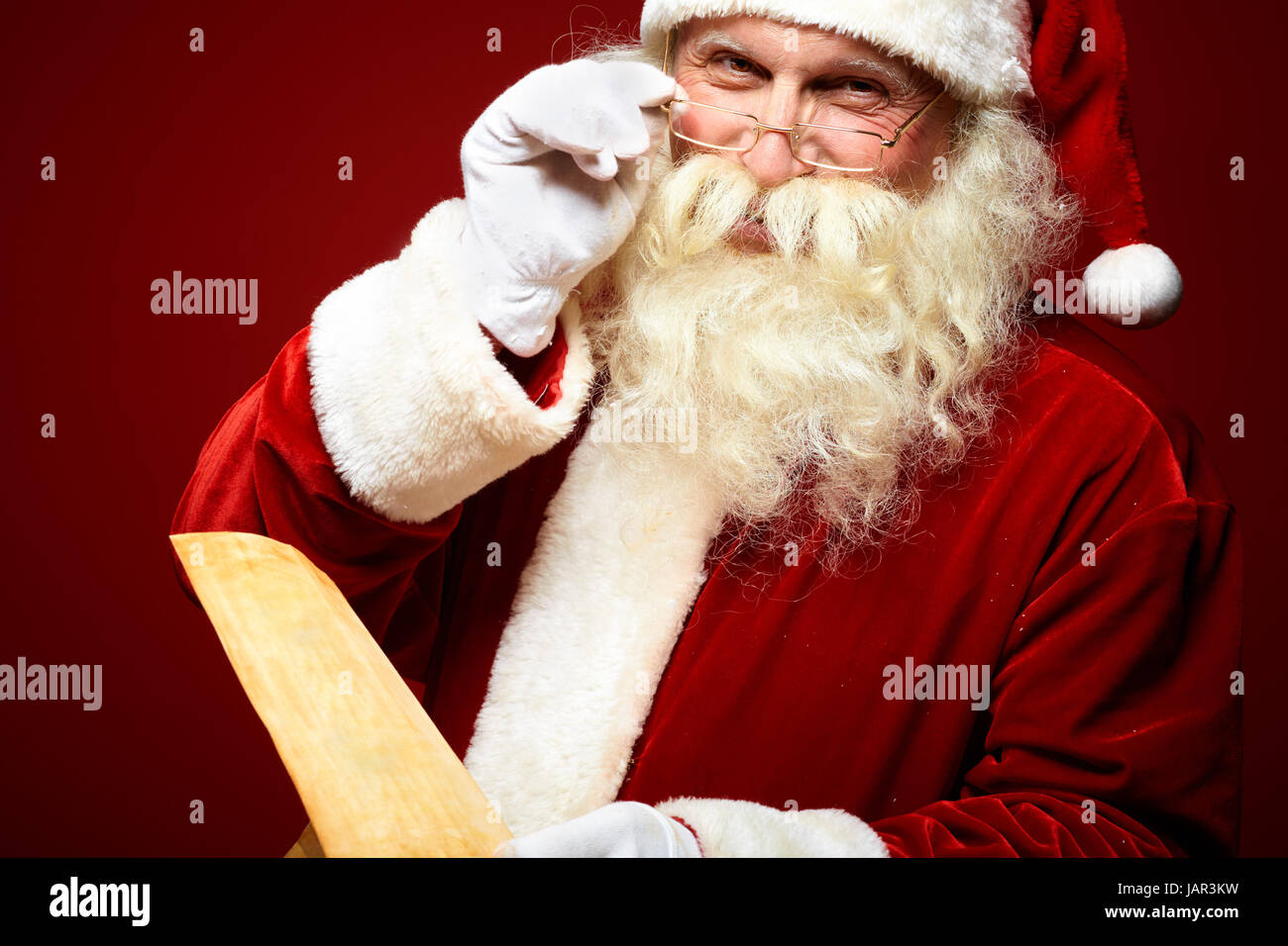 Portrait of happy Santa Claus holding Christmas letter in his hands and ...