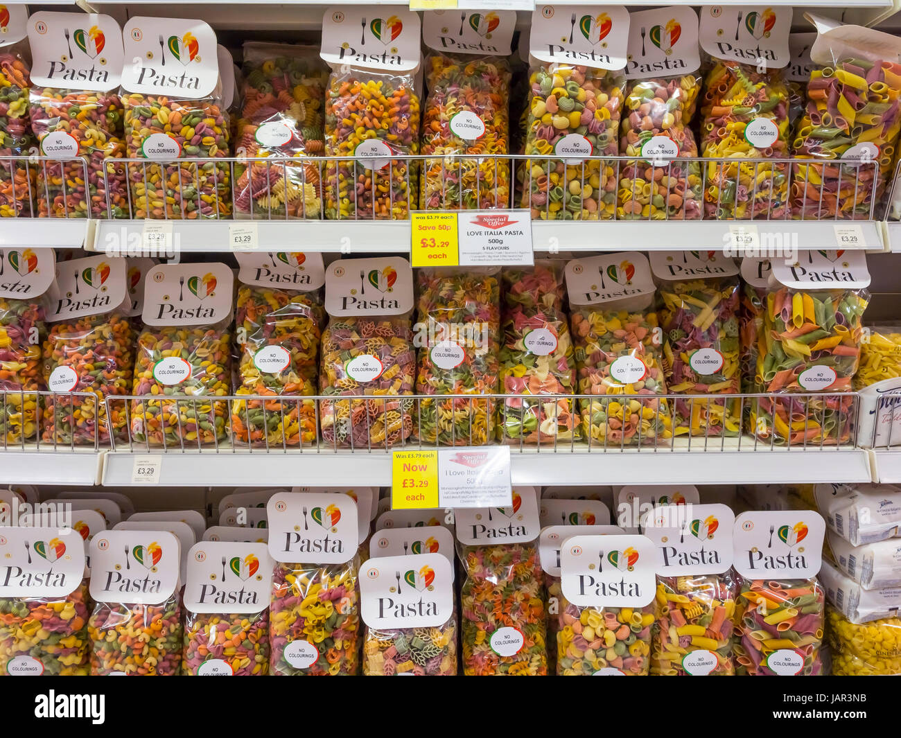 Grocers shop display of 500g bags of Love Italia Pasta offering one of many types of Pasta in each bag in which several different colours are included Stock Photo