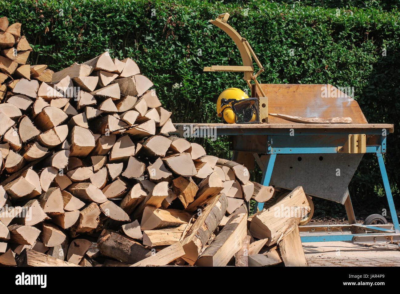 circular saw with wood logs and forestry helmet Stock Photo