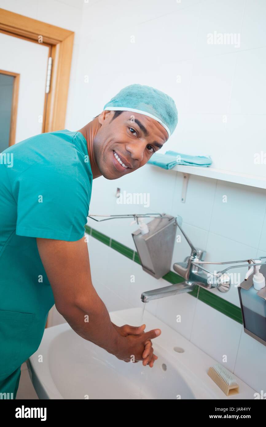 Smiling male surgeon washing his hands Stock Photo