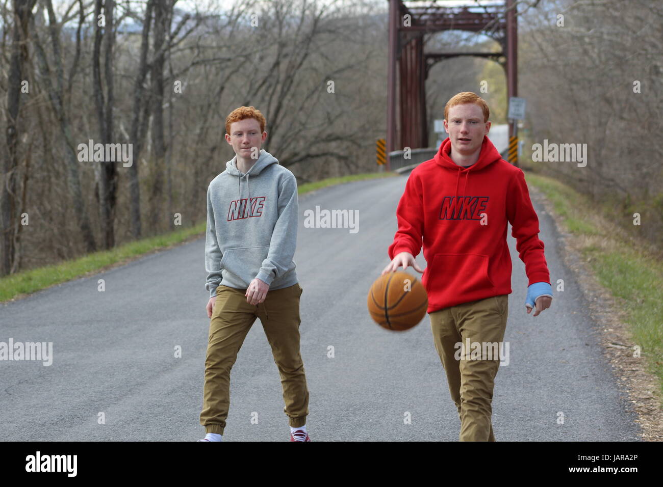 Identical Twin Brothers Playing Basketball In The Street Stock Photo