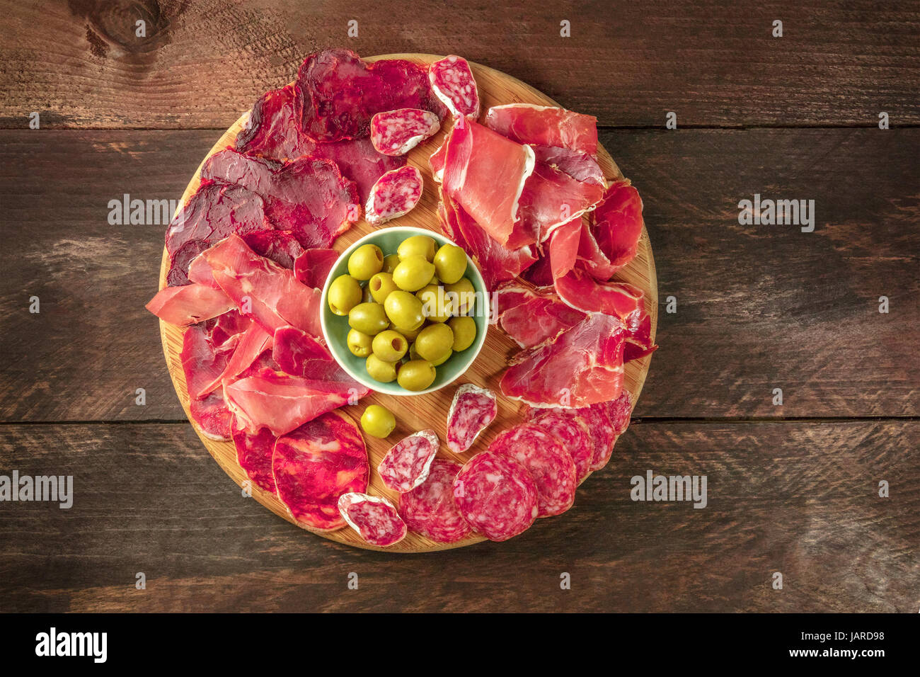 An overhead photo of a Spanish cold meats platter with jamon and payes