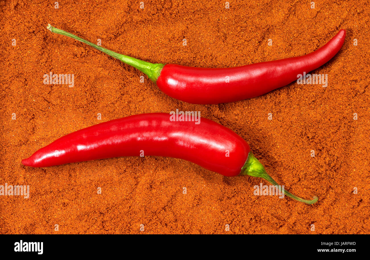 two red hot chilli fruits in chili powder background Stock Photo Alamy