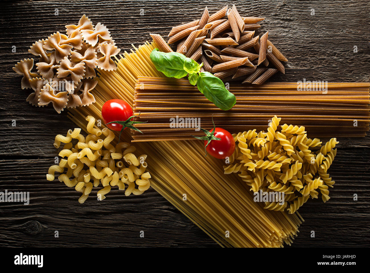 Raw pasta with basil and tomato overhead shoot Stock Photo Alamy