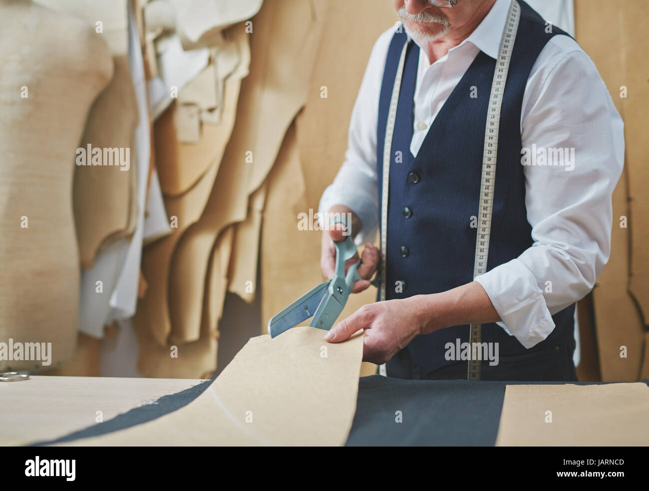Experienced Old Tailor Working in Small Atelier Stock Photo