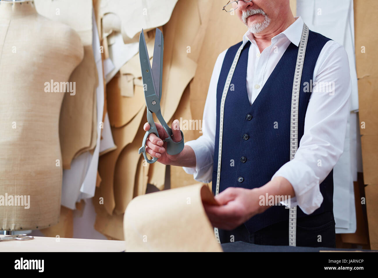 Senior  Tailor Working in Small Atelier Stock Photo