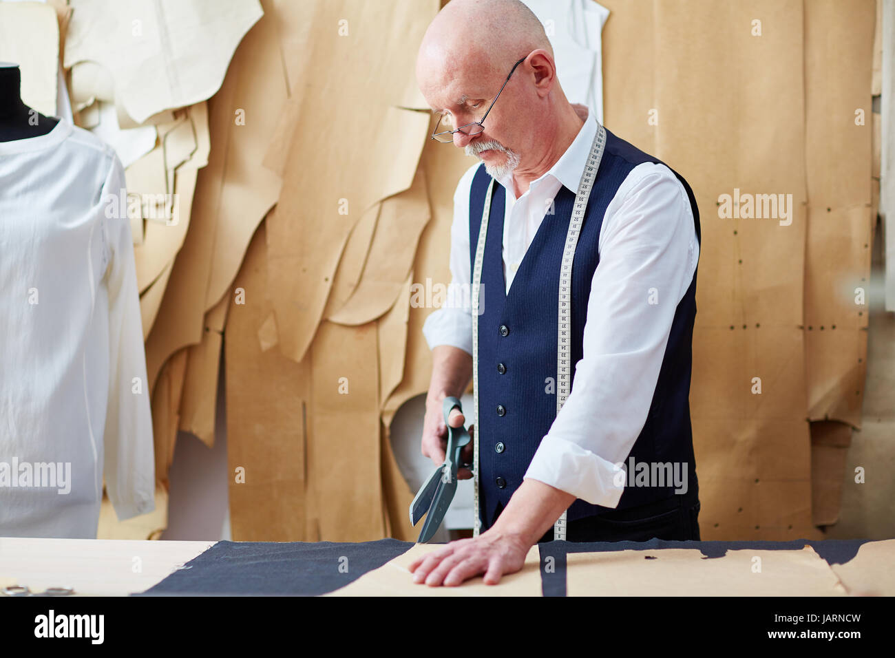 Skilled Senior  Tailor Working in Small Atelier Stock Photo
