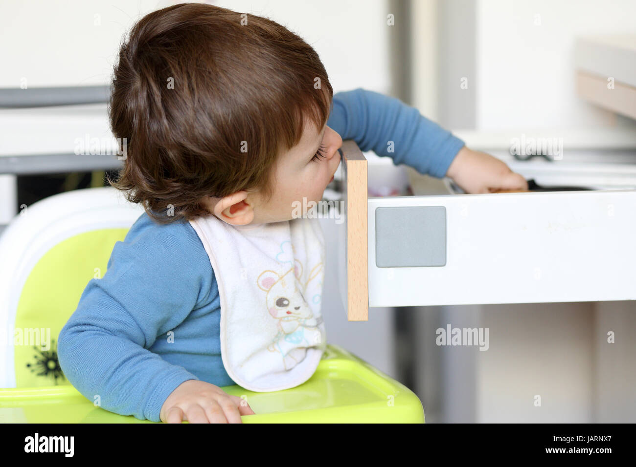 Details Of A Little Boy Who Is Trying To Catch A Knife In A Drawer