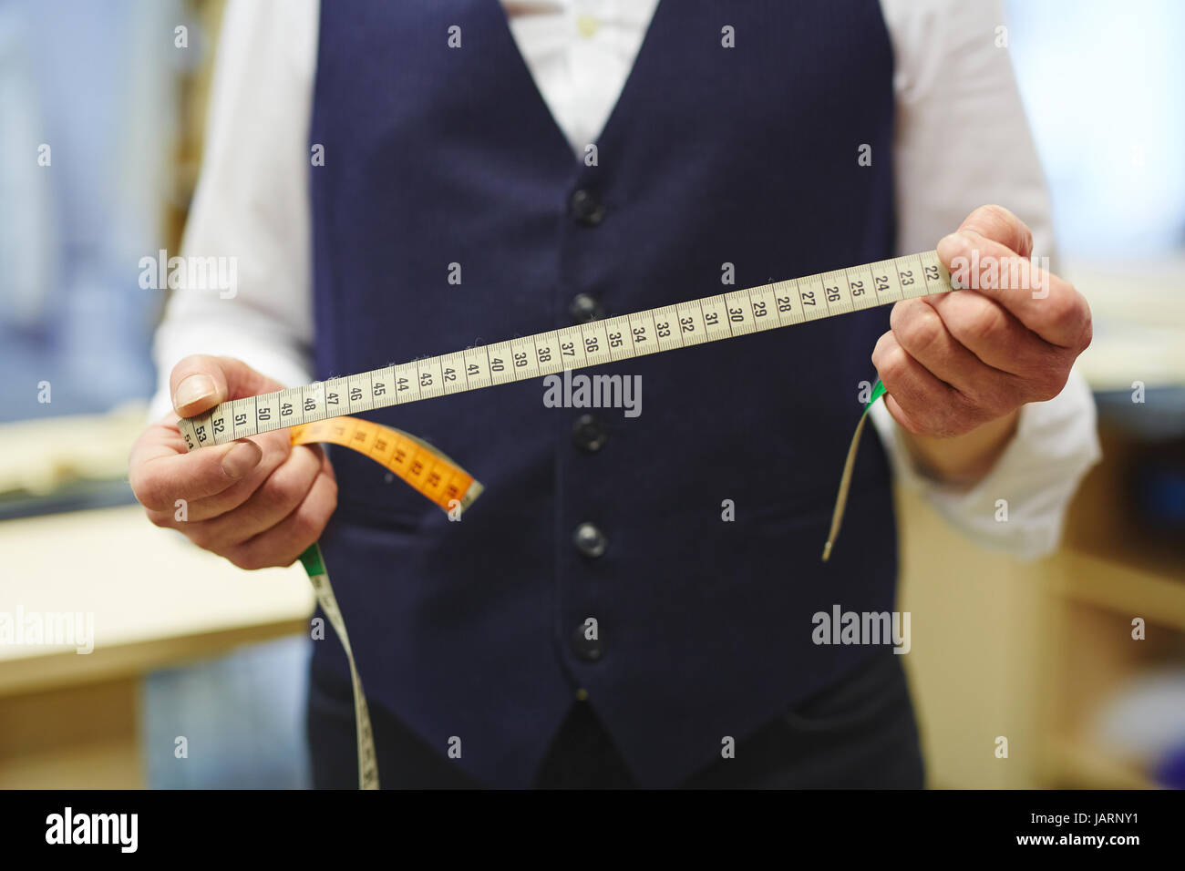 Old-Fashioned Tailor Working in Atelier Stock Photo