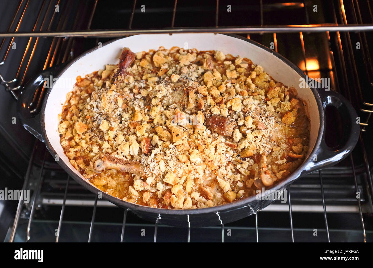 Classic French dish of Cassoulet made with confit duck legs sausages pork belly white beans and breadcrumbs Stock Photo