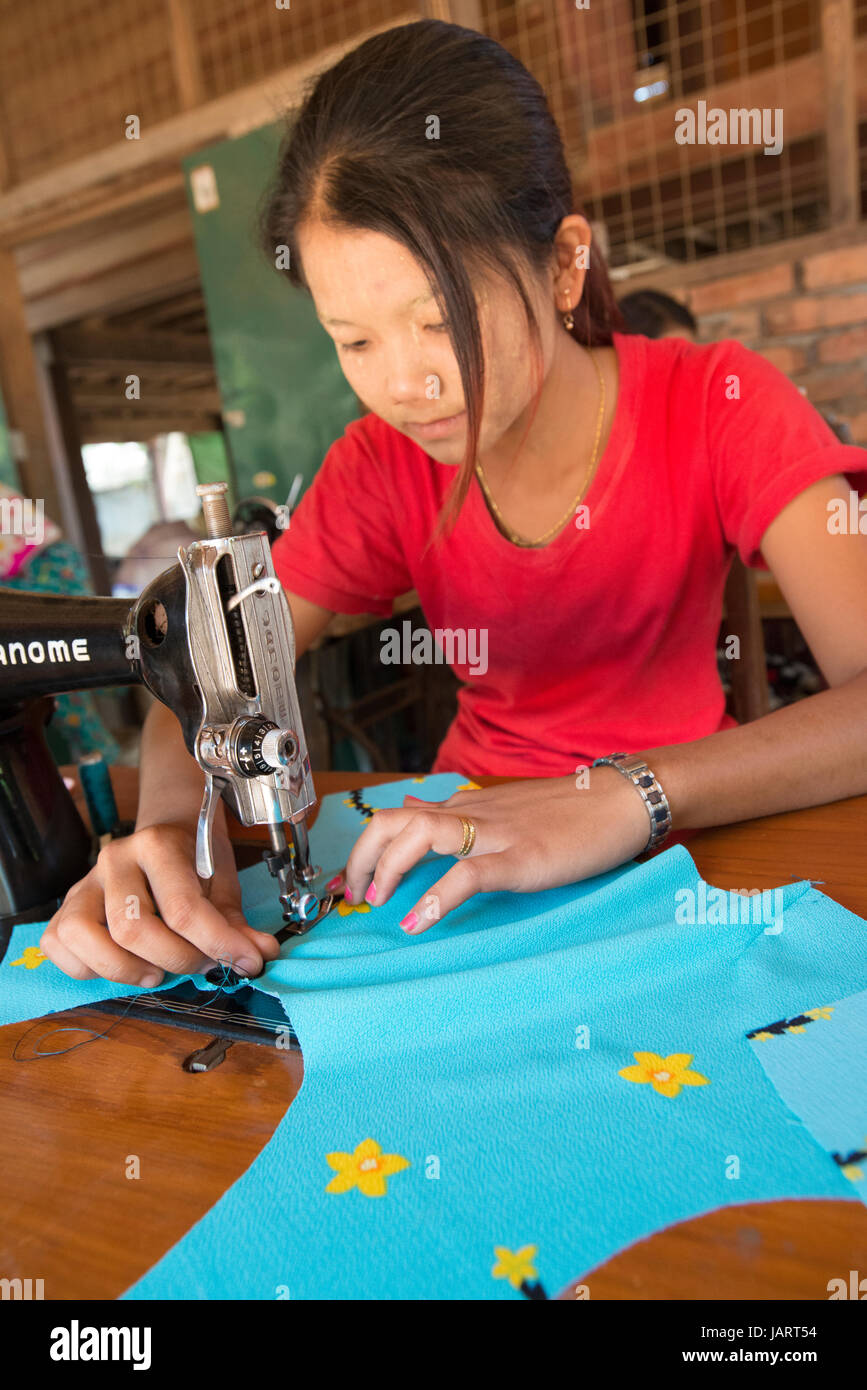 A tailor sews material at her place of work at Ye, Myanmar,(Burma) Stock Photo