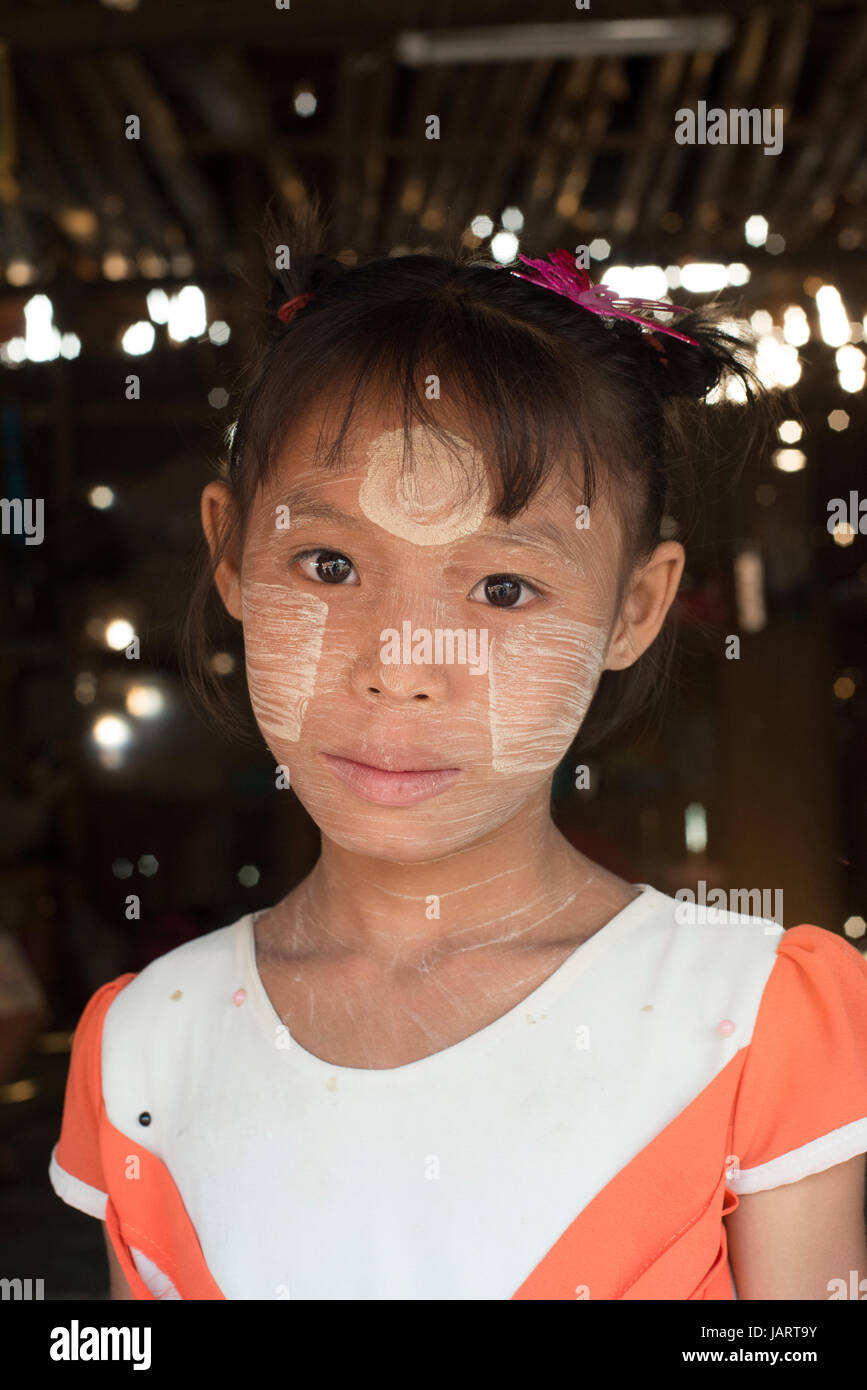 A young girl with thanakha (a traditional cosmetic) applied to her cheeks, poses for the camera in Ye, Myanmar (Burma) Stock Photo