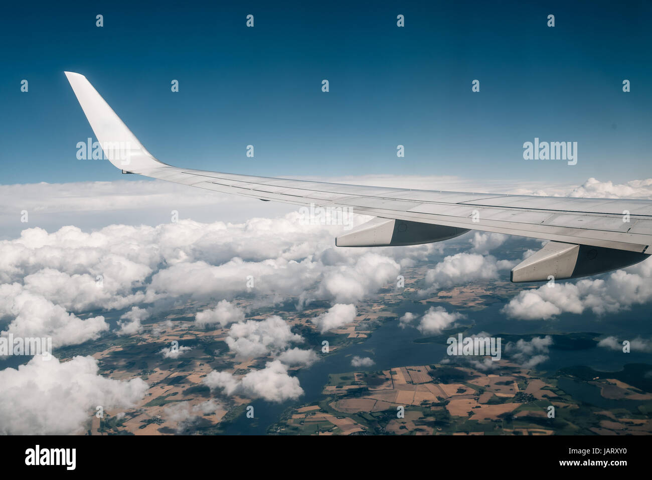 Wing of an airplane flying above the clouds Stock Photo - Alamy