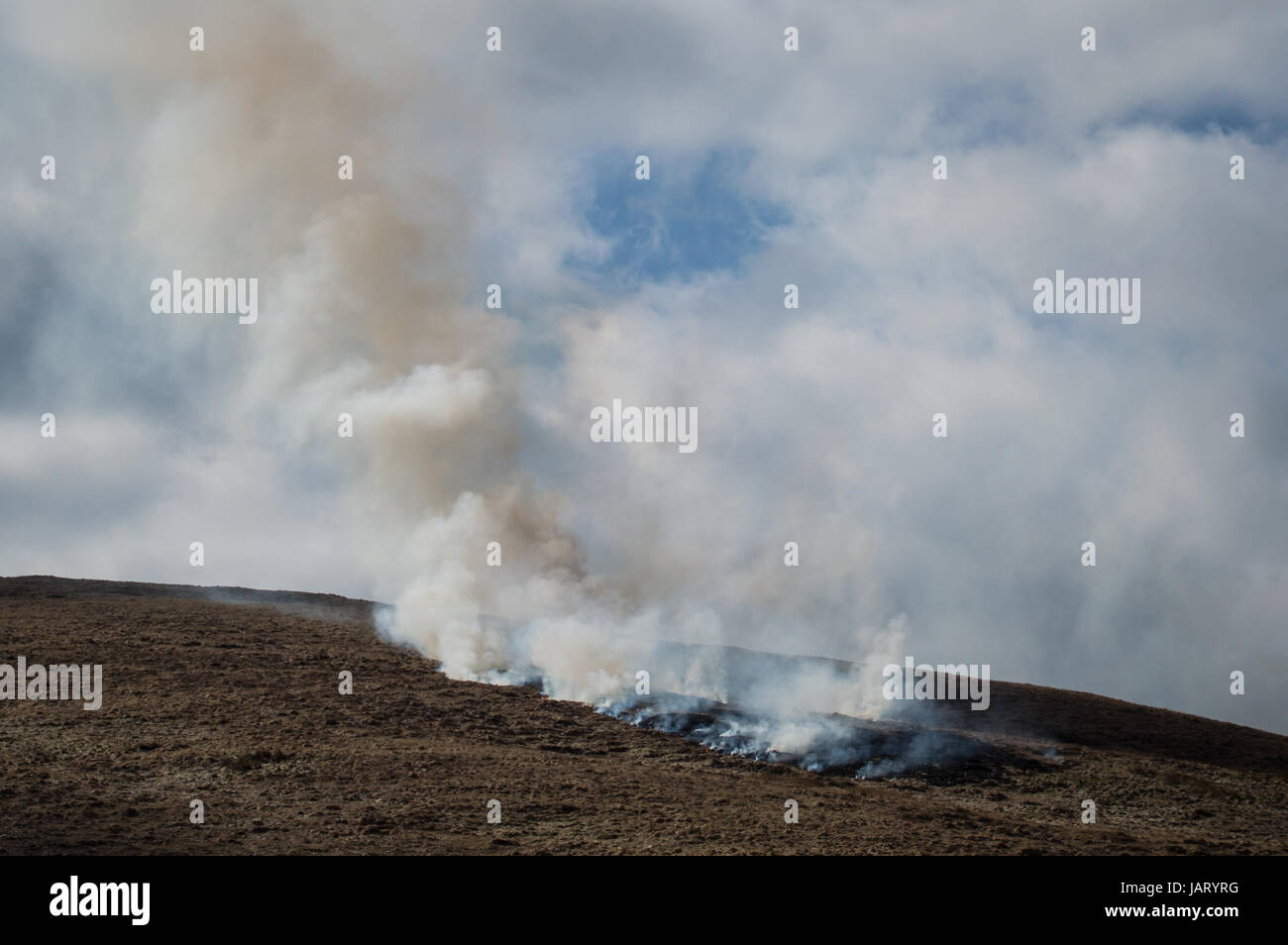 Fire on barren mountainside Stock Photo