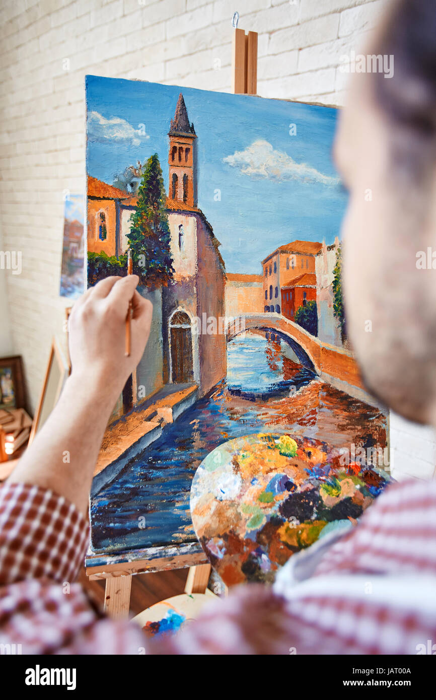 Talented Artist Painting Beautiful Picture in Workshop Stock Photo