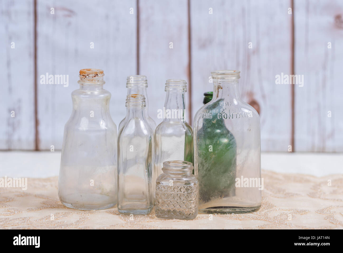 Old bottles grouped together in front of a wood background Stock Photo