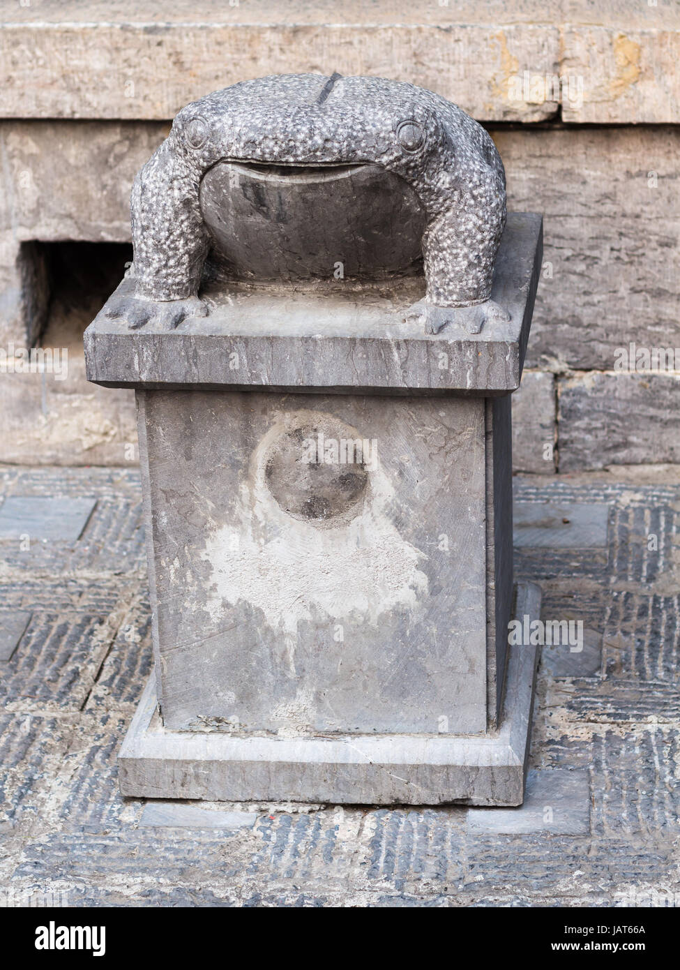 LUOYANG, CHINA - MARCH 20, 2017: stone toad statue near temple of Chinese Buddhist monument Longmen Grottoes in spring. The complex was inscribed upon Stock Photo