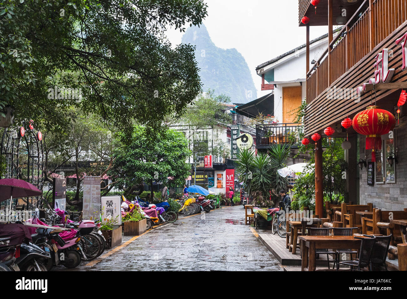 YANGSHUO, CHINA - MARCH 30, 2017: people and cafe on alley in Yangshuo town in spring. Town is resort destination for domestic and foreign tourists be Stock Photo