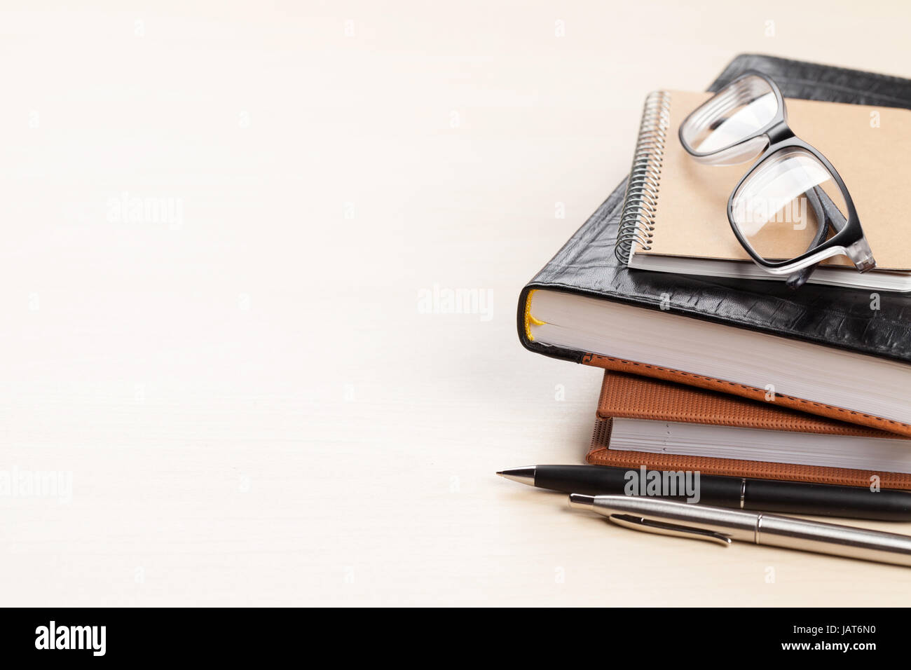 Wooden office desk with supplies. Notepad, pen and glasses. With space for your text Stock Photo