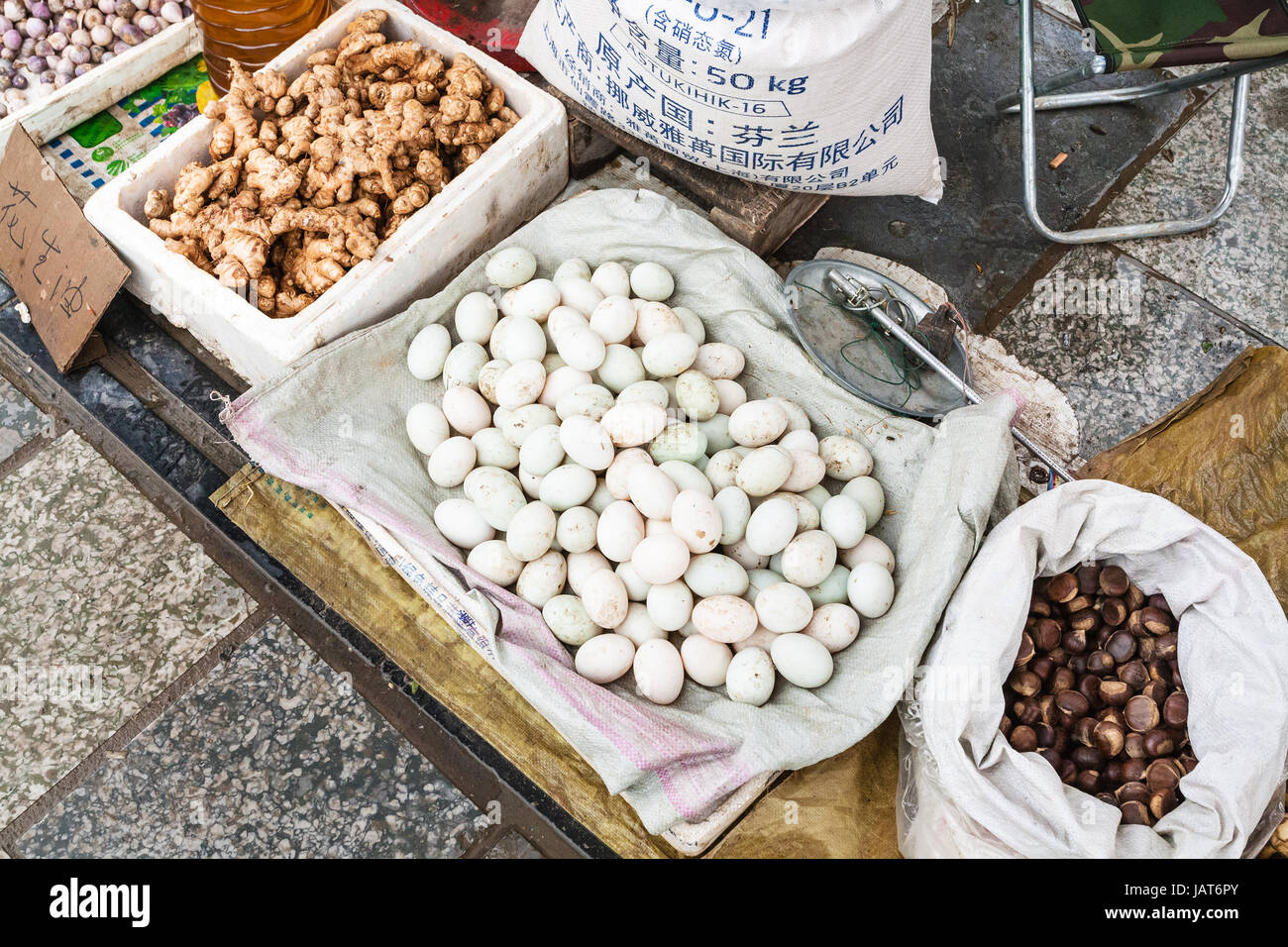 YANGSHUO, CHINA - MARCH 30, 2017: eggs, gingers, chestnuts on street outdoor market in Yangshuo in spring. Town is resort destination for domestic and Stock Photo