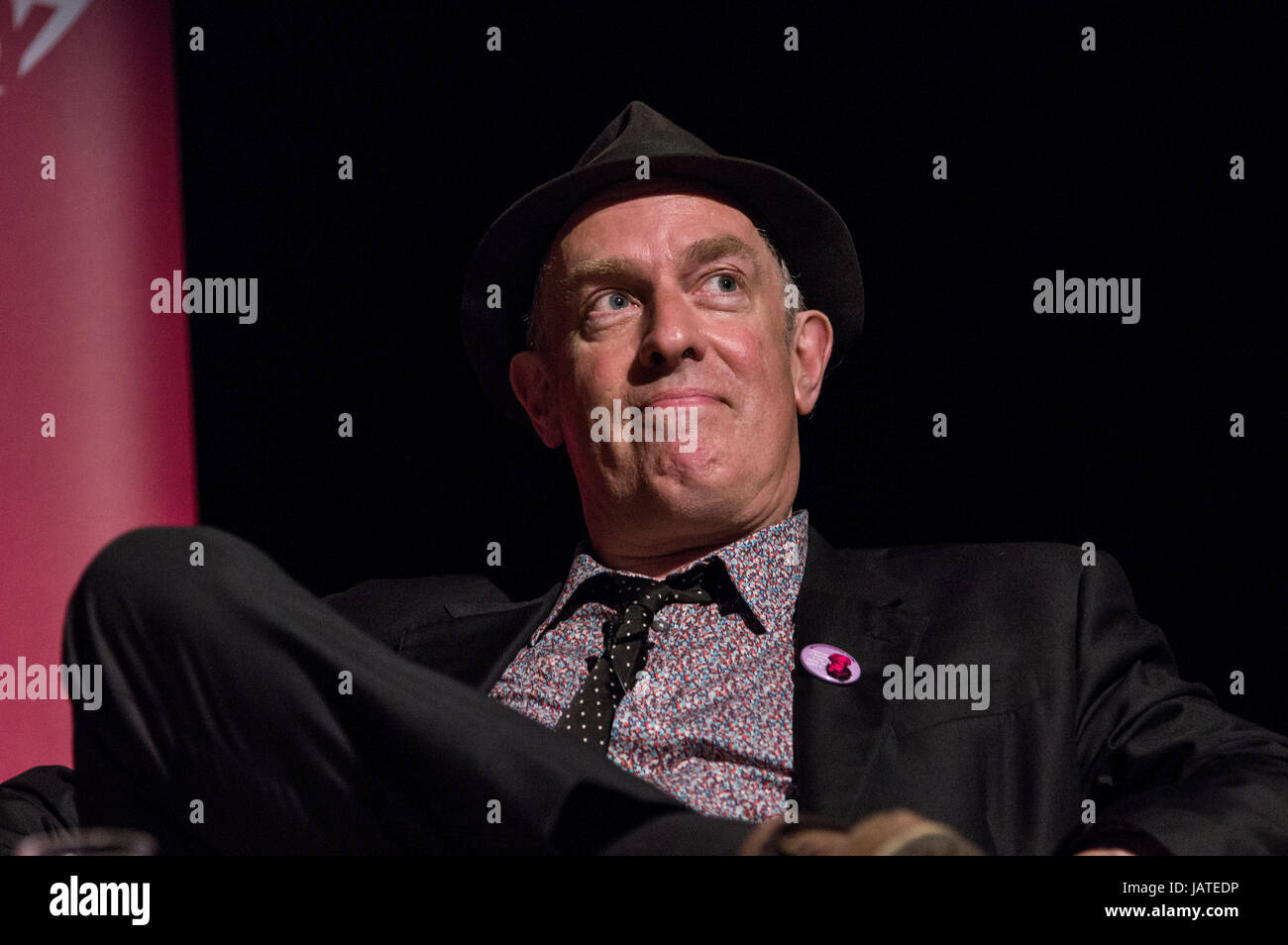 Cartoonist and writer Martin Ronson on stage in June 2017 at the 8th annual Stoke Newington Literary Festival against a black background. Stock Photo