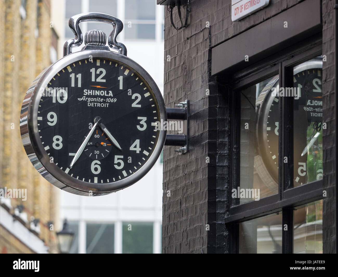 A giant Shinola watch hangs outside a Shinola store just off London's famous Carnaby Street. Stock Photo