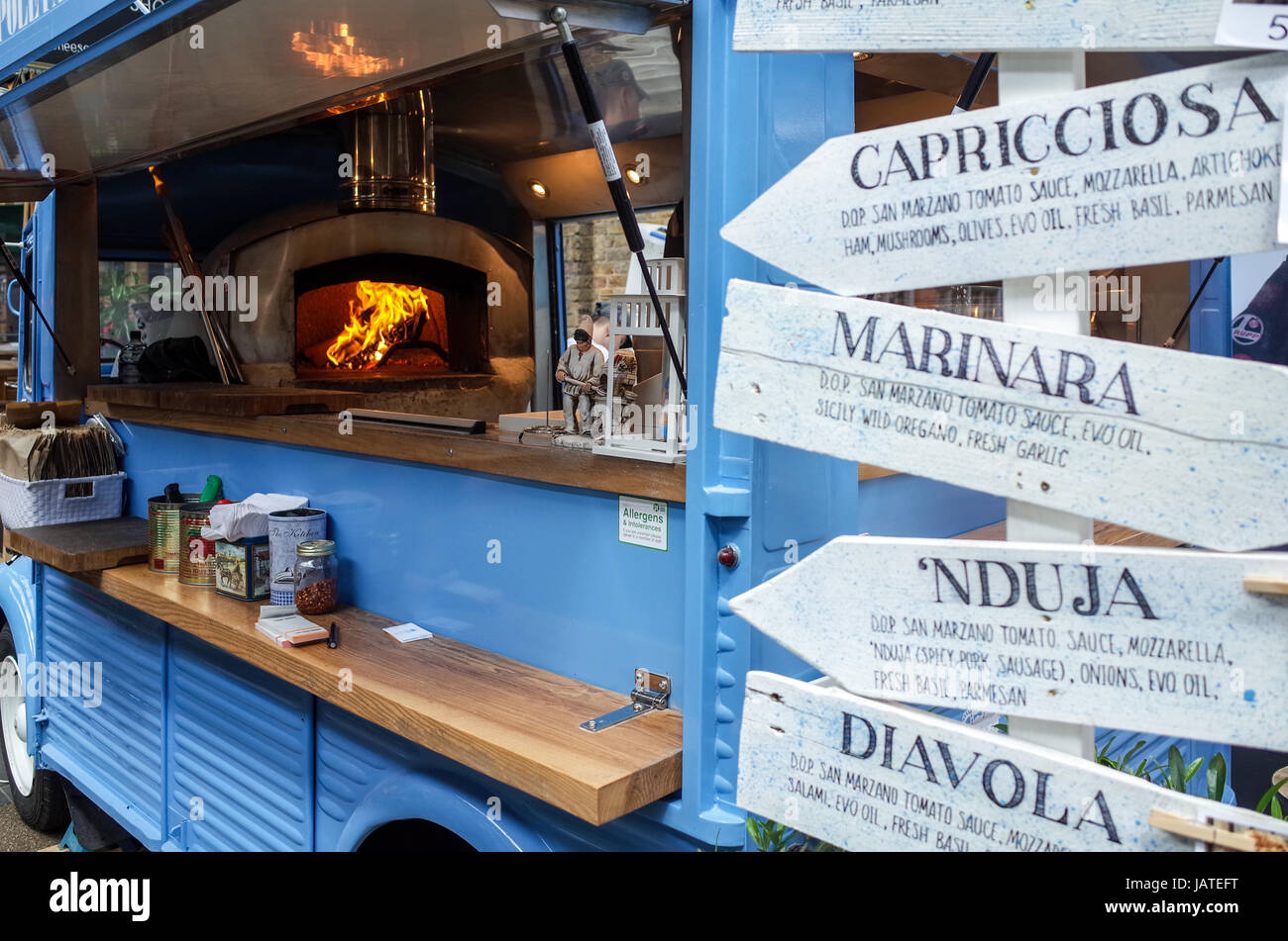 A mobile Pizza van fires up the oven in London's Spitalfields market ready for the lunchtime rush. London Street Food Pizza Van. Stock Photo