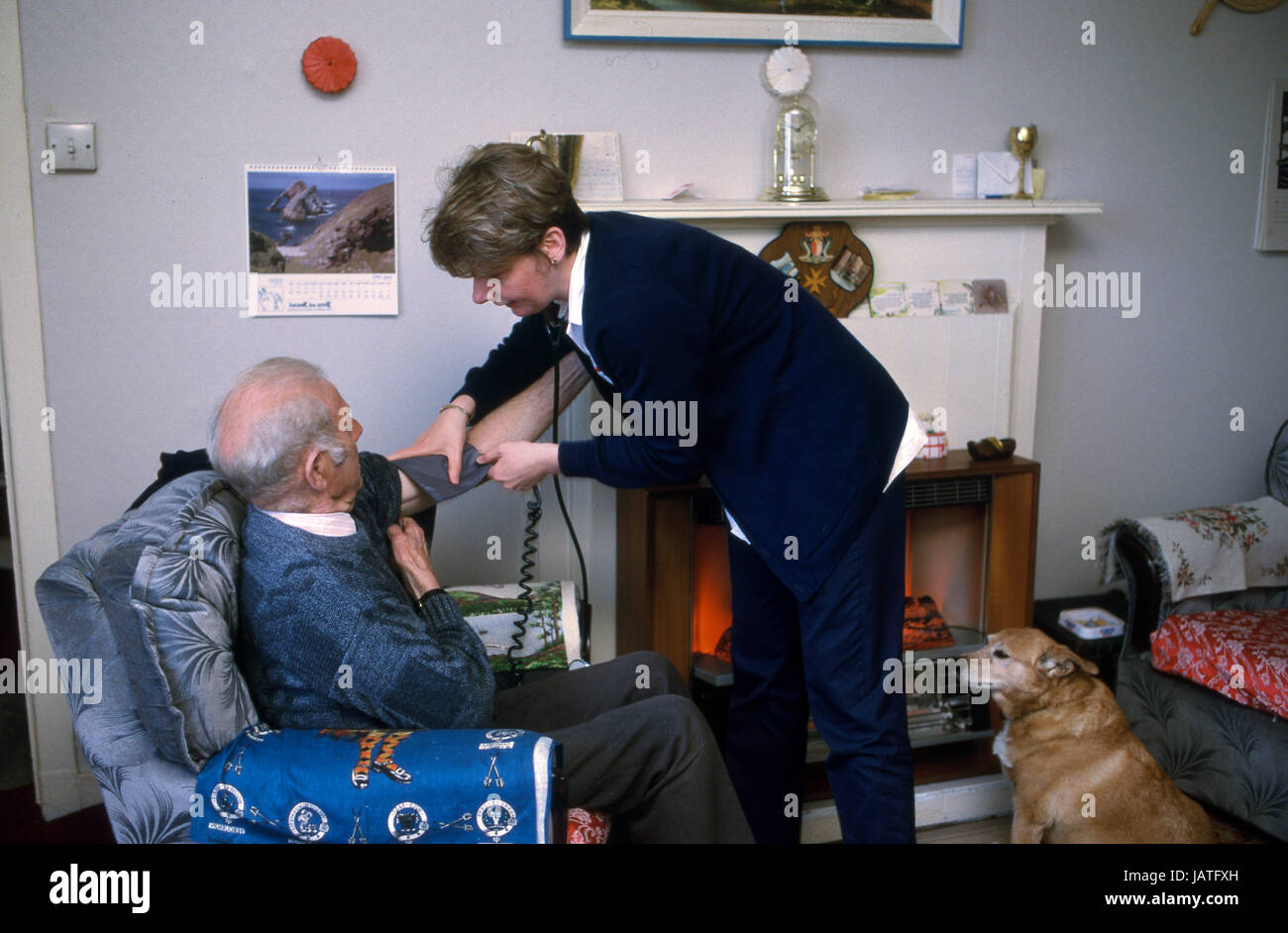 District Nurse on a home visit taking an elderly man's blood pressure Stock Photo