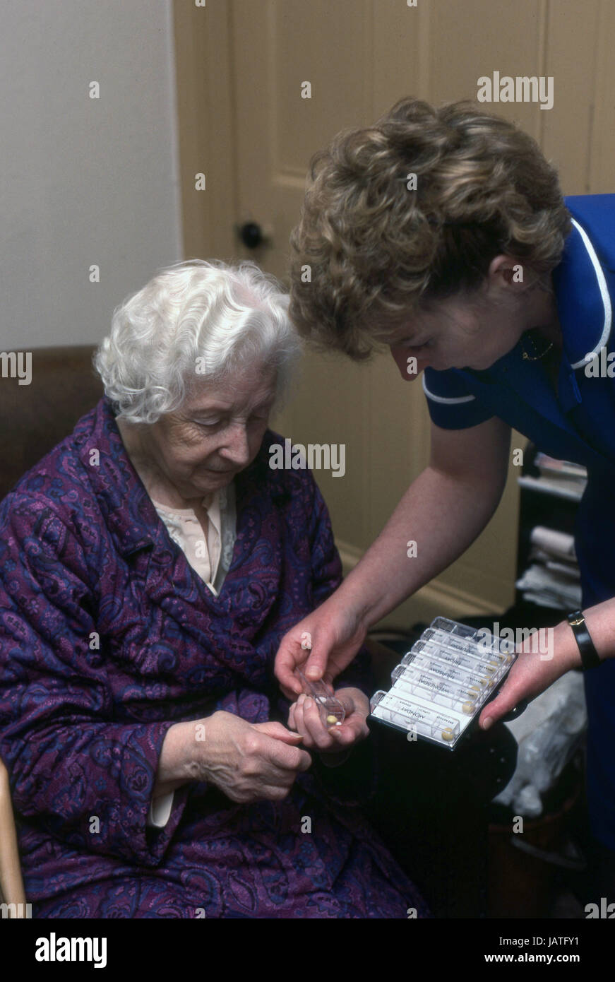 district nurse on a home visit assisting elderly woman with her daily medication Stock Photo