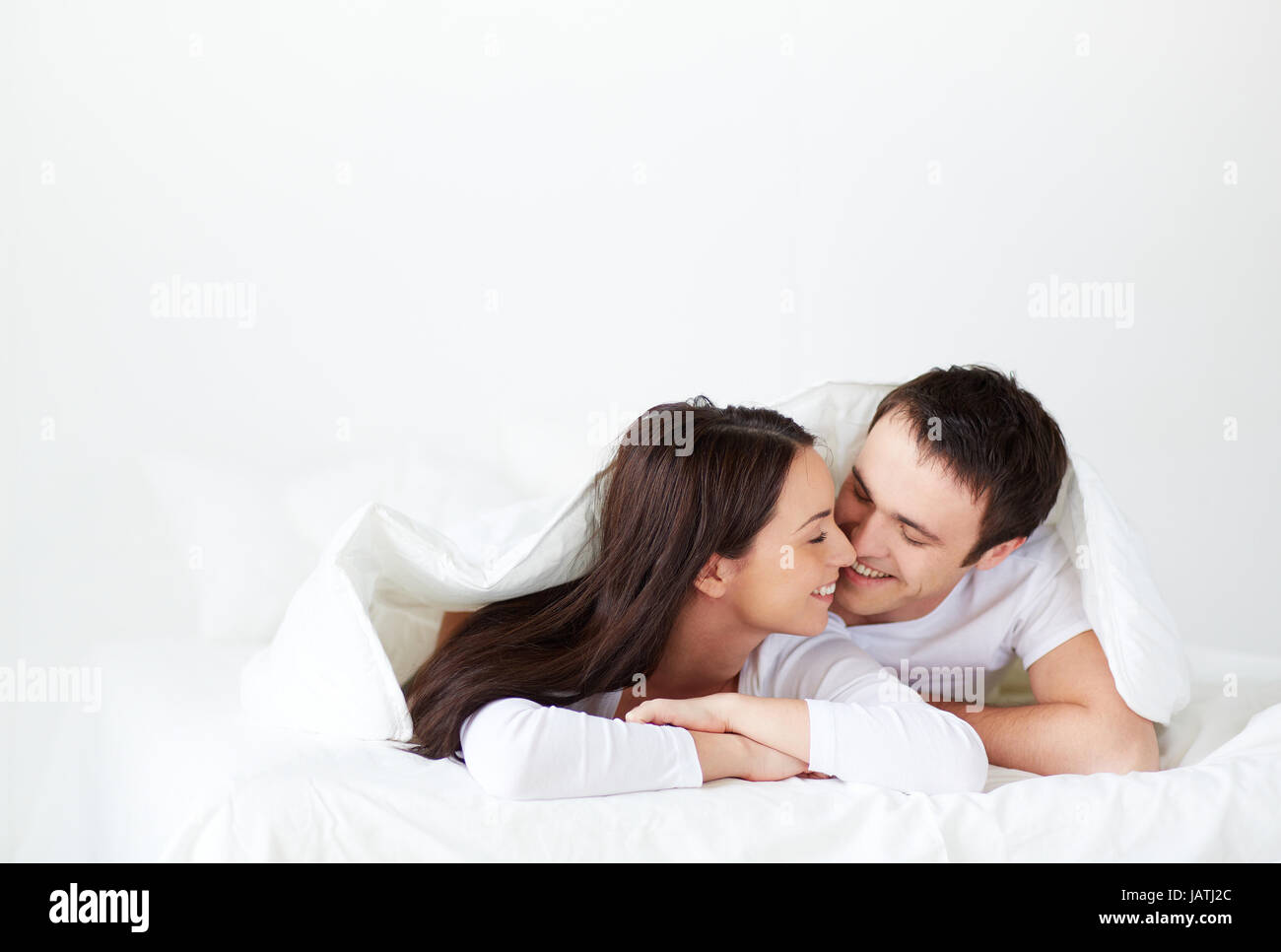 Amorous couple lying in bed hi-res stock photography and images - Alamy