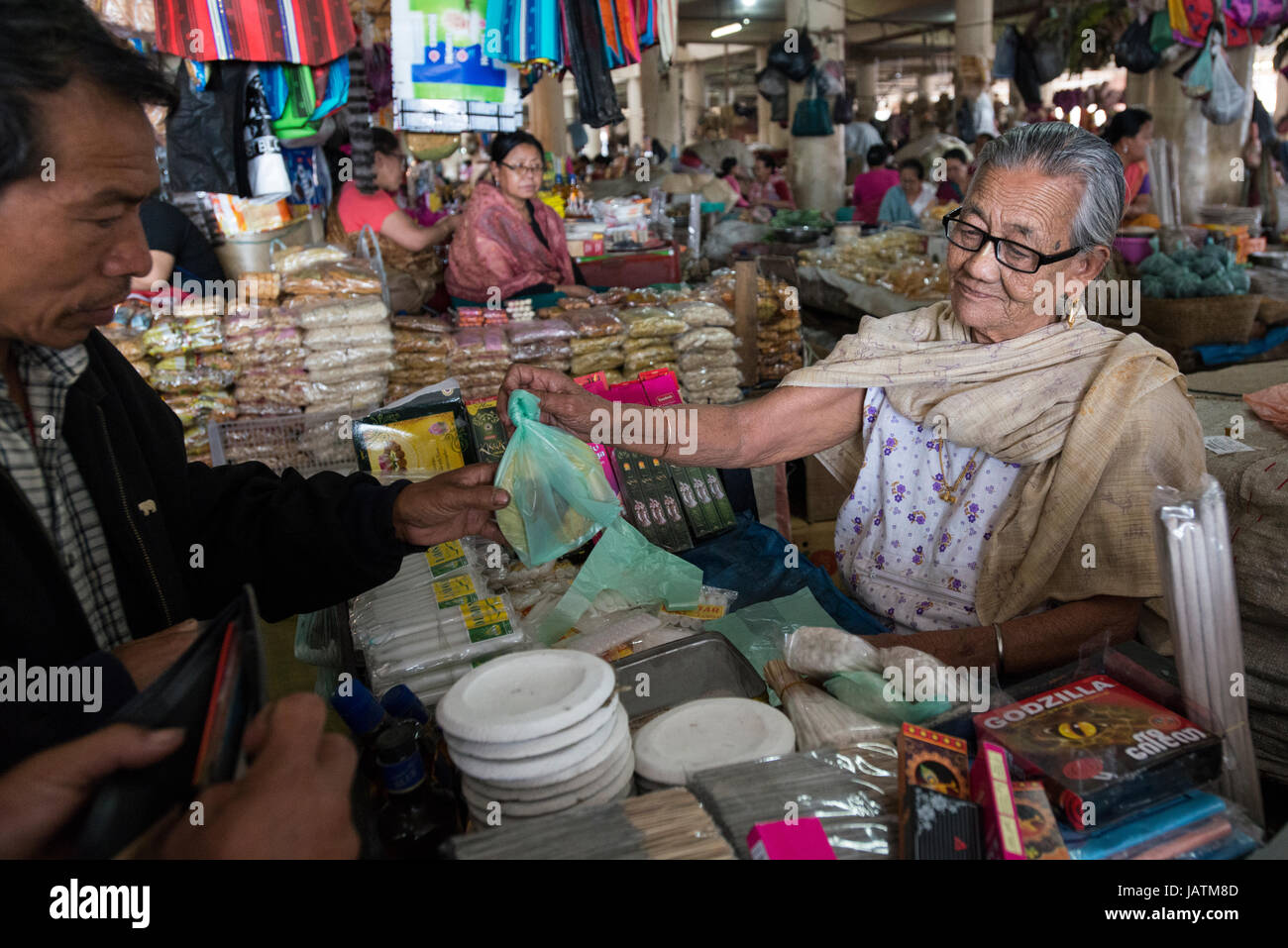 A market trader sells her wares at an indoor market stall in Imphal, Manipur, India Stock Photo
