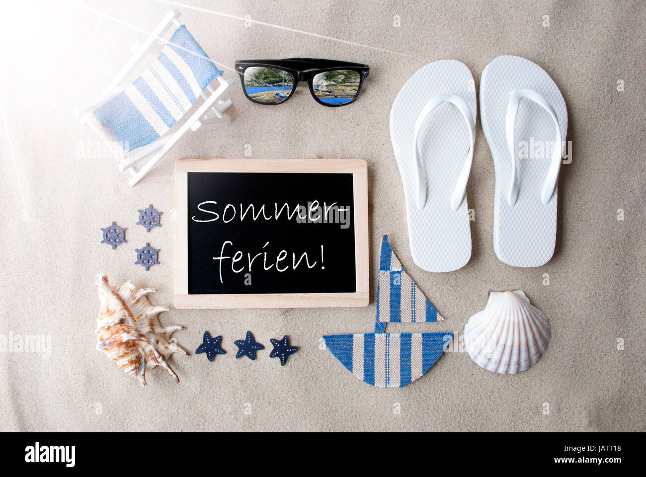 Sunny Blackboard On Sand, Sommerferien Means Summer Holidays Stock Photo