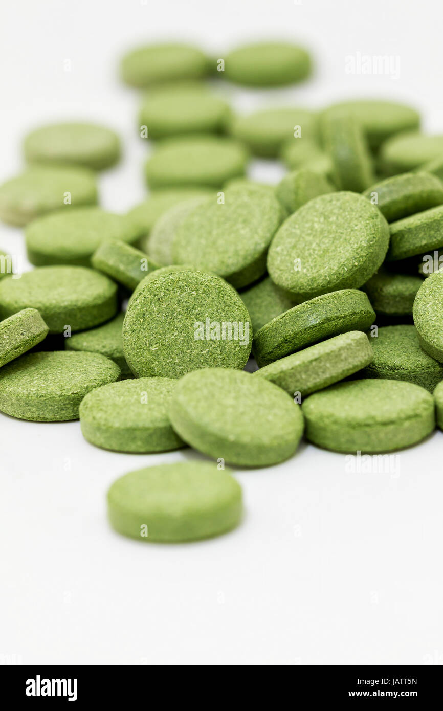 Green chlorophyll tablets on white background Stock Photo Alamy