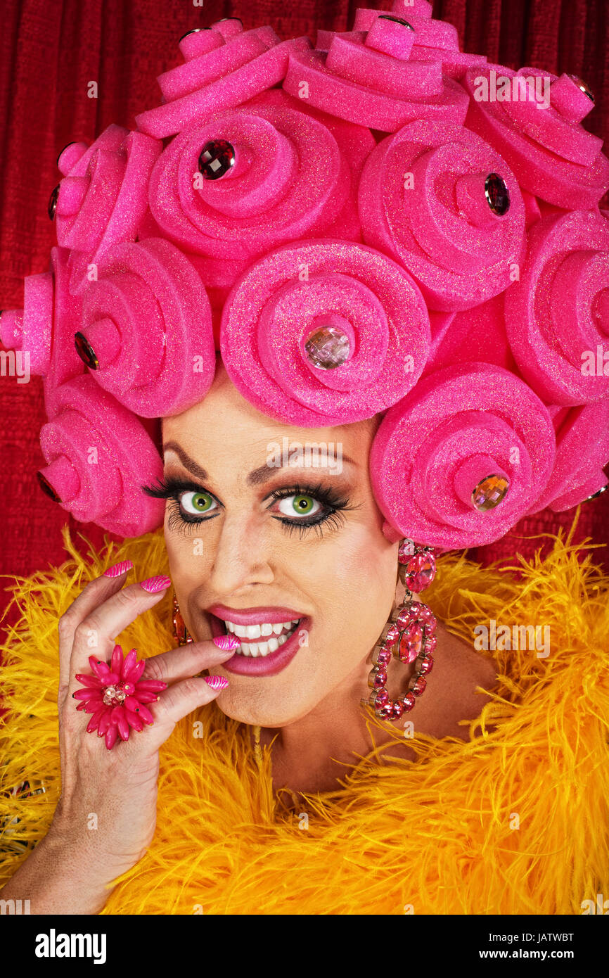 Grinning drag queen in plastic wig biting fingernails Stock Photo - Alamy